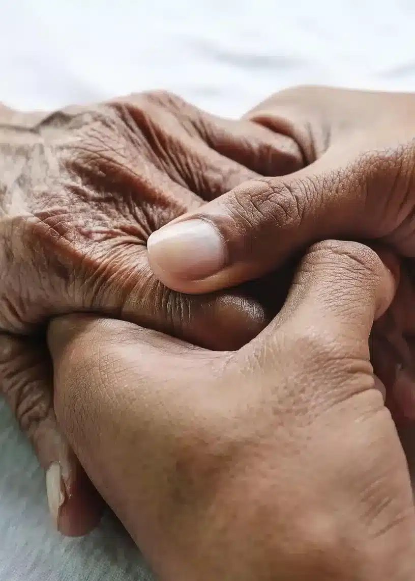 Doula tenant la main ridée d'une personne âgée en fin de vie – accompagnement palliatif et présence humaine au chevet dans les Yvelines (78)
